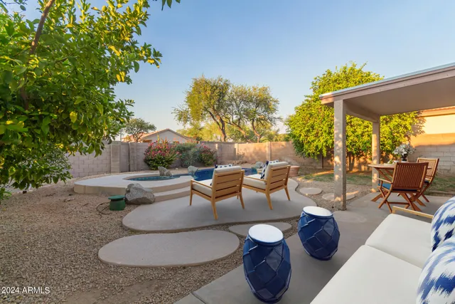 a view of a patio with couches and table and chairs and potted plants