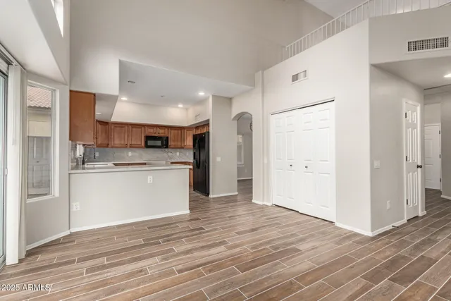 a view of a kitchen with white cabinets and wooden floor