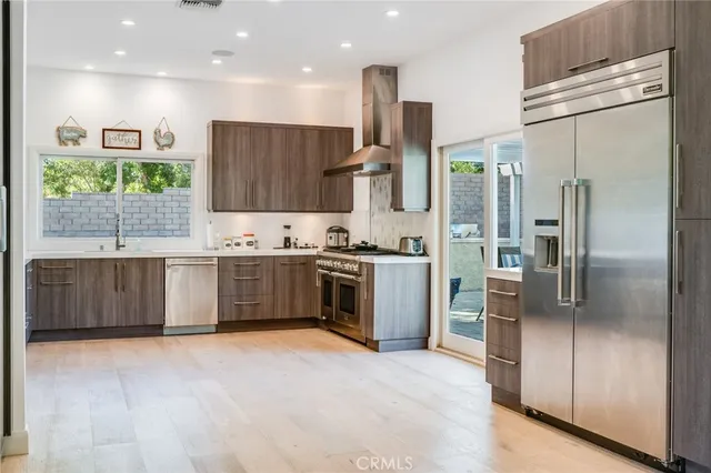 a kitchen with stainless steel appliances a refrigerator and a sink