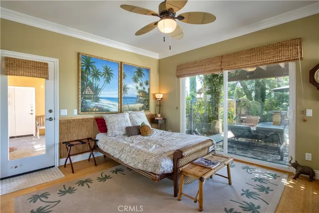 a spacious bedroom with a bed a dresser and a chandelier