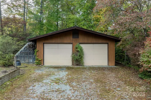 a backyard of a house with plants and large trees