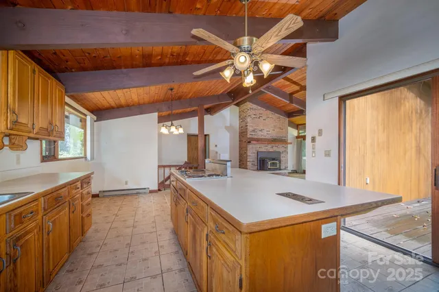 a kitchen with stainless steel appliances granite countertop a sink a stove counter space cabinets and a large window