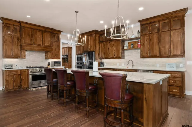a kitchen with stainless steel appliances granite countertop a stove a sink and a refrigerator