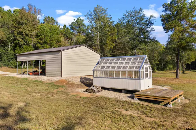 a view of a house with backyard and sitting area