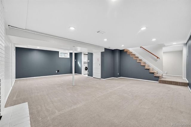 a view of an empty room with stairs and closet