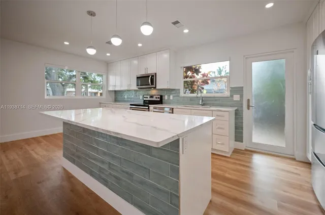 a kitchen with white cabinets stainless steel appliances and sink