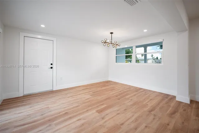 a view of a room with wooden floor and window