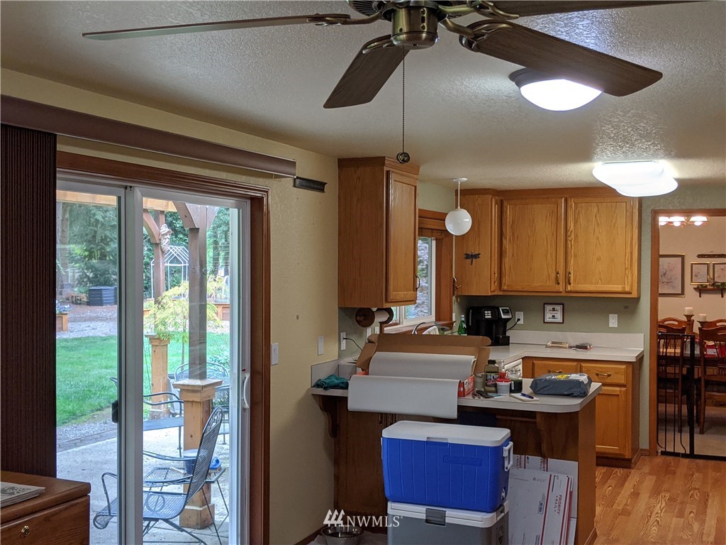 5428 133rd Avenue Southwest Rochester, WA 98579 - Photo 19 of 21 a kitchen with stainless steel appliances granite countertop a stove a refrigerator and a dining table with wooden floor