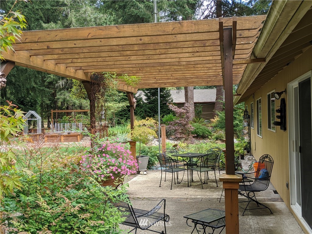 5428 133rd Avenue Southwest Rochester, WA 98579 - Photo 21 of 21 a patio with table and chairs and potted plants