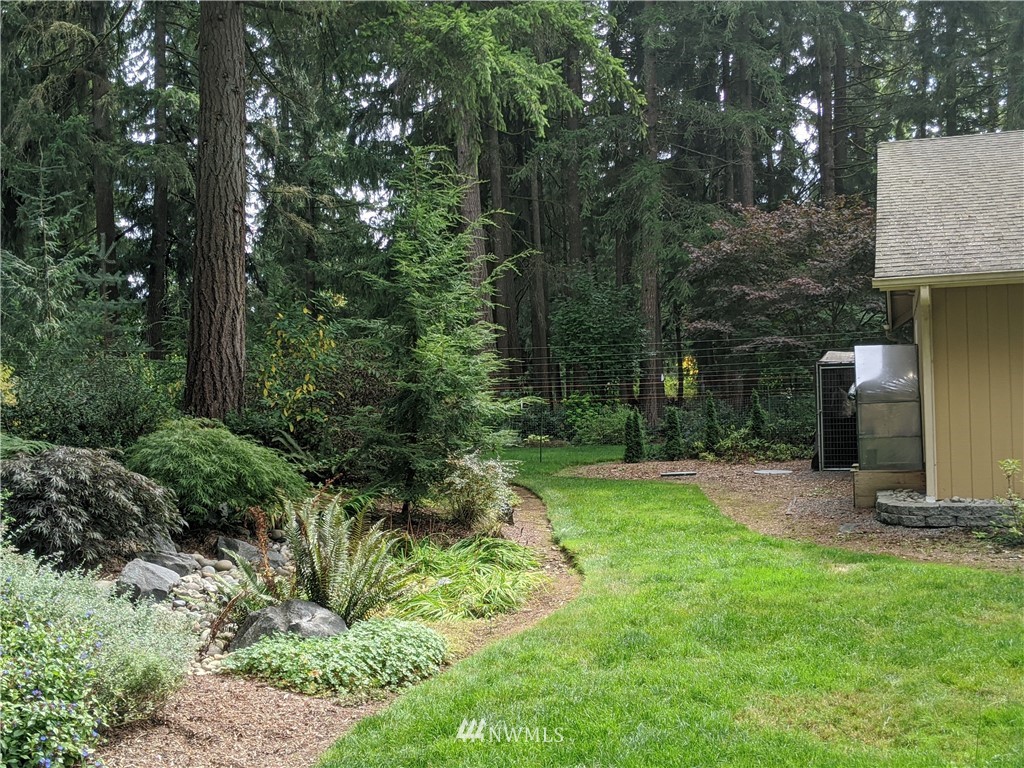 5428 133rd Avenue Southwest Rochester, WA 98579 - Photo 7 of 21 a backyard of a house with lots of green space and fountain