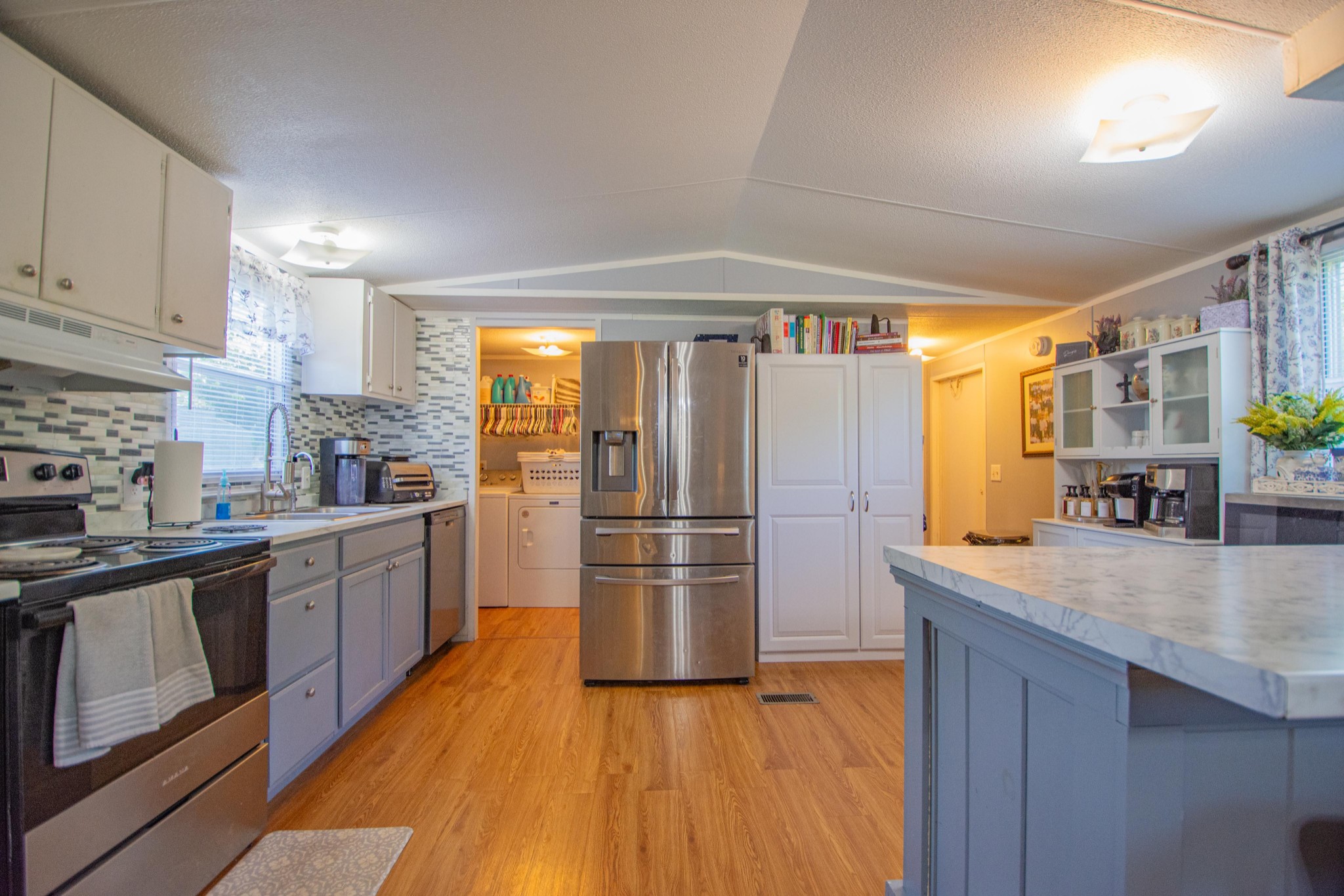 2490 Tackets Branch Road Prospect, TN 38477 - Photo 8 of 42 a kitchen with stainless steel appliances granite countertop a refrigerator a sink dishwasher a stove and white countertops with wooden floor