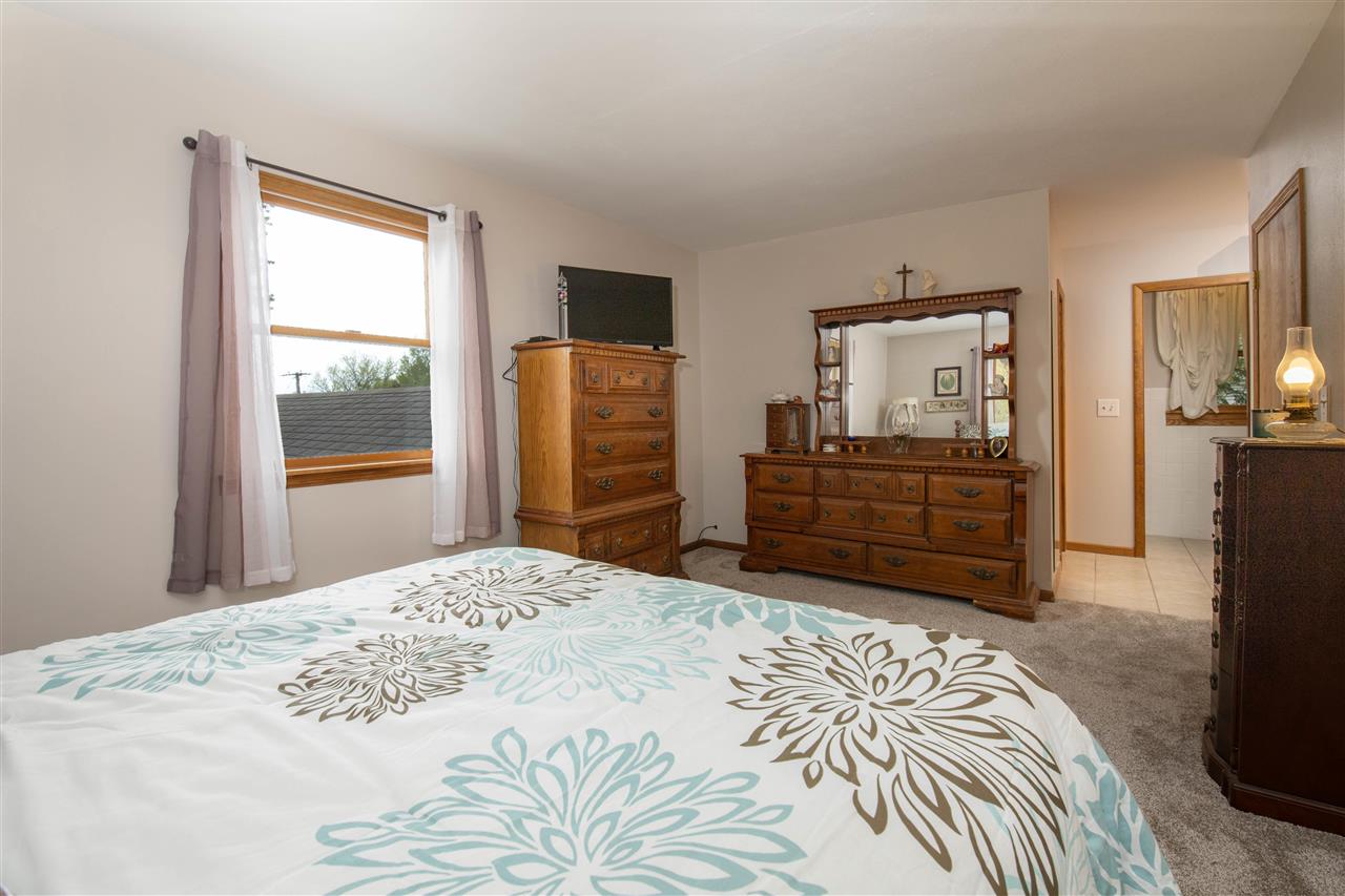 8488 Grange Hall Road Garden Prairie, IL 61038 - Photo 15 of 35 a bedroom with a bed and dresser with mirror