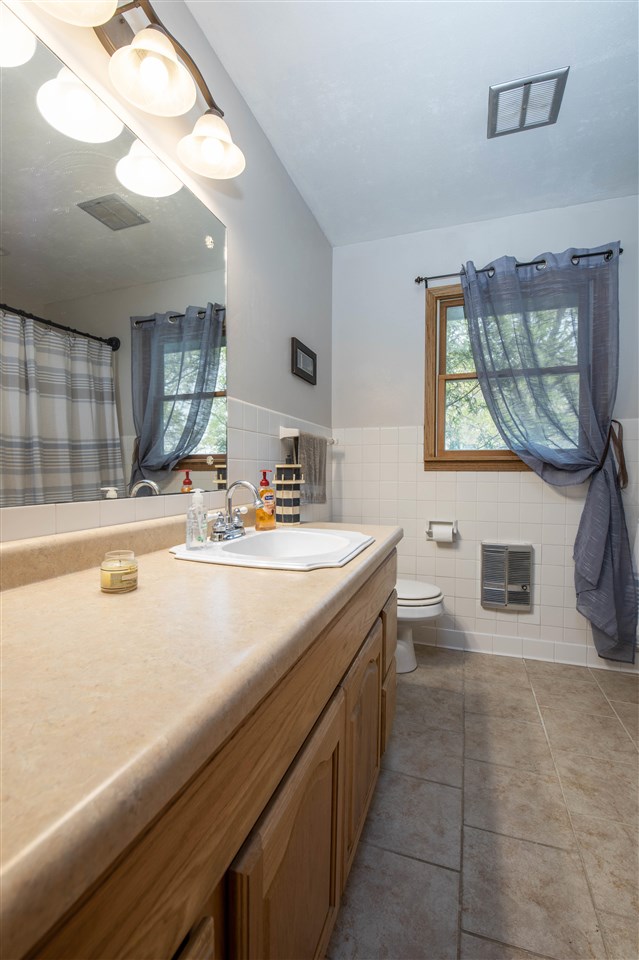 8488 Grange Hall Road Garden Prairie, IL 61038 - Photo 21 of 35 a bathroom with a sink a mirror and a bathtub