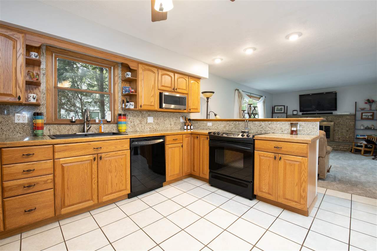 8488 Grange Hall Road Garden Prairie, IL 61038 - Photo 10 of 35 a kitchen with stainless steel appliances granite countertop a stove top oven sink and cabinets
