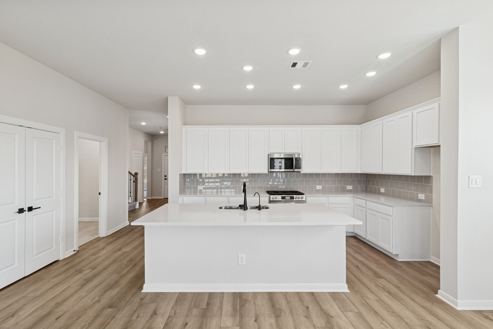 26502 Delightful Drive Hockley, TX 77447 - Photo 19 of 50 a large kitchen with stainless steel appliances granite countertop a sink a stove a refrigerator and a cabinets with wooden floor