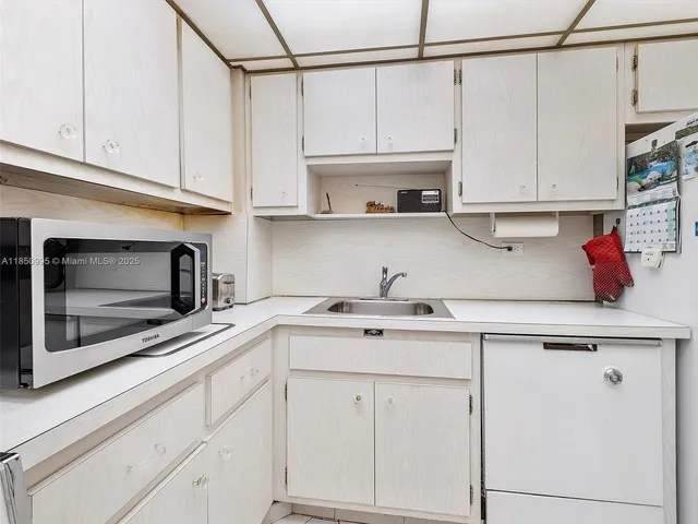 a kitchen with white cabinets and white appliances