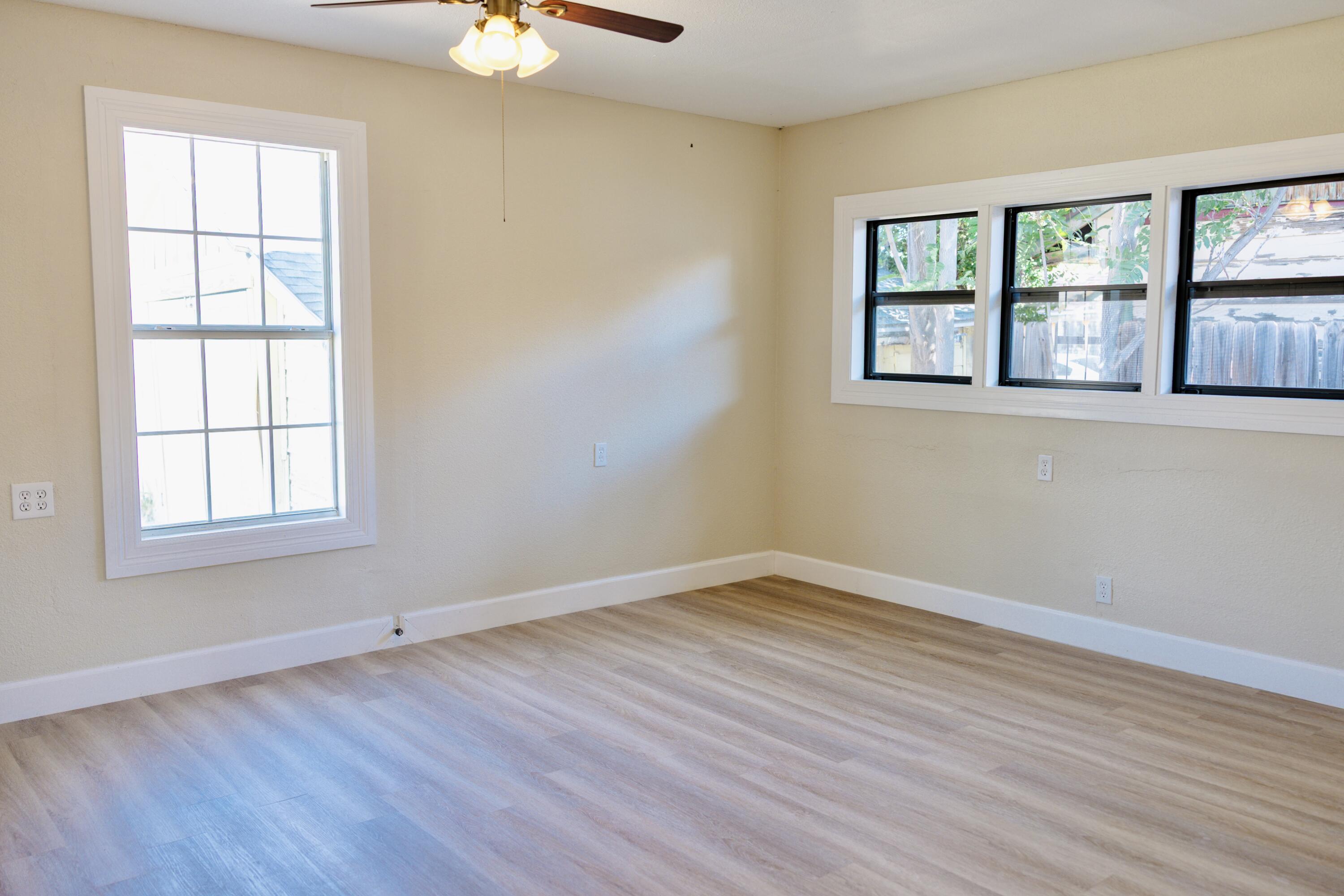 1410 West 8th Street Plainview, TX 79072 - Photo 12 of 24 an empty room with wooden floor and windows
