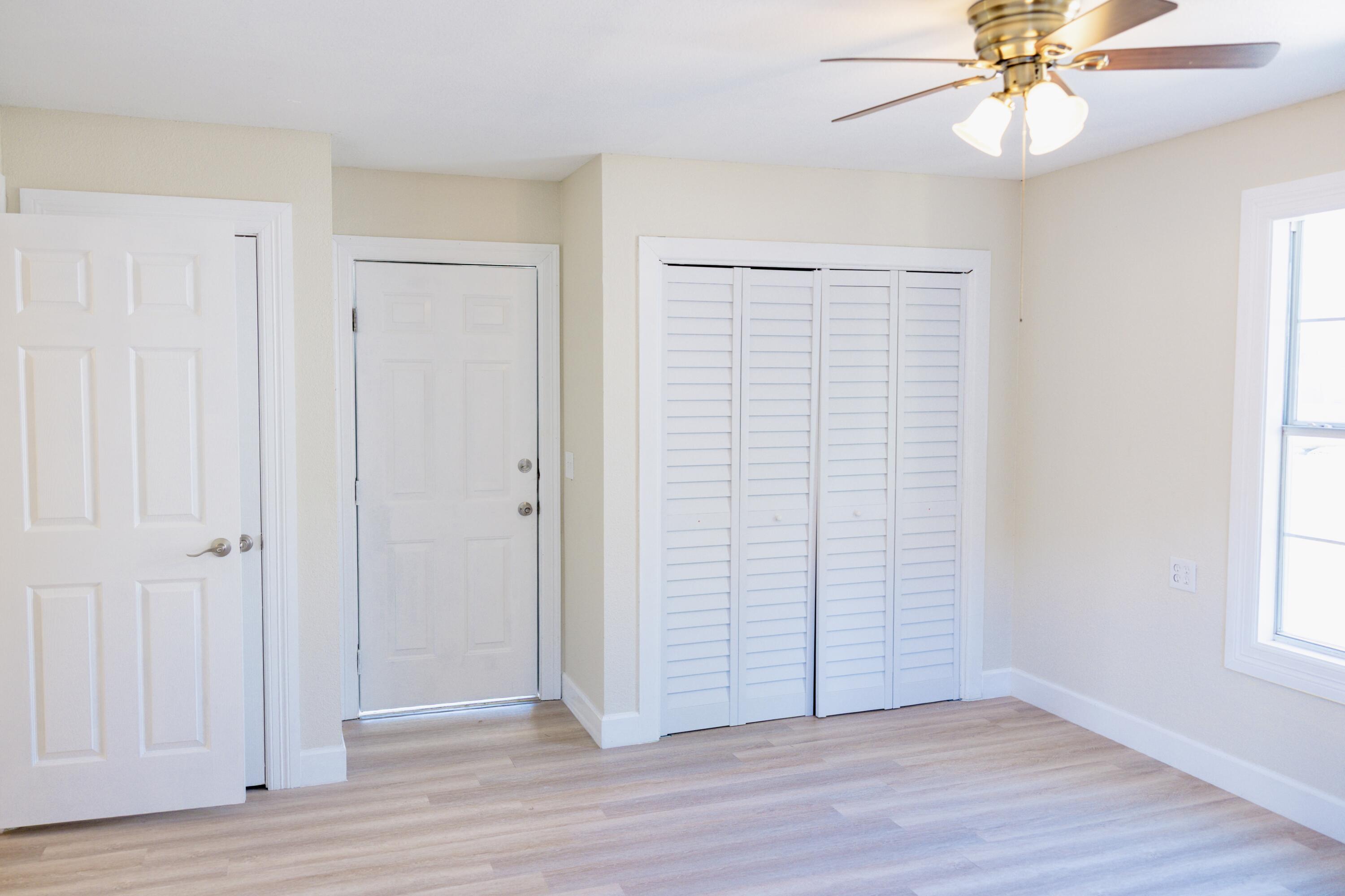 1410 West 8th Street Plainview, TX 79072 - Photo 13 of 24 an empty room with wooden floor closet and windows