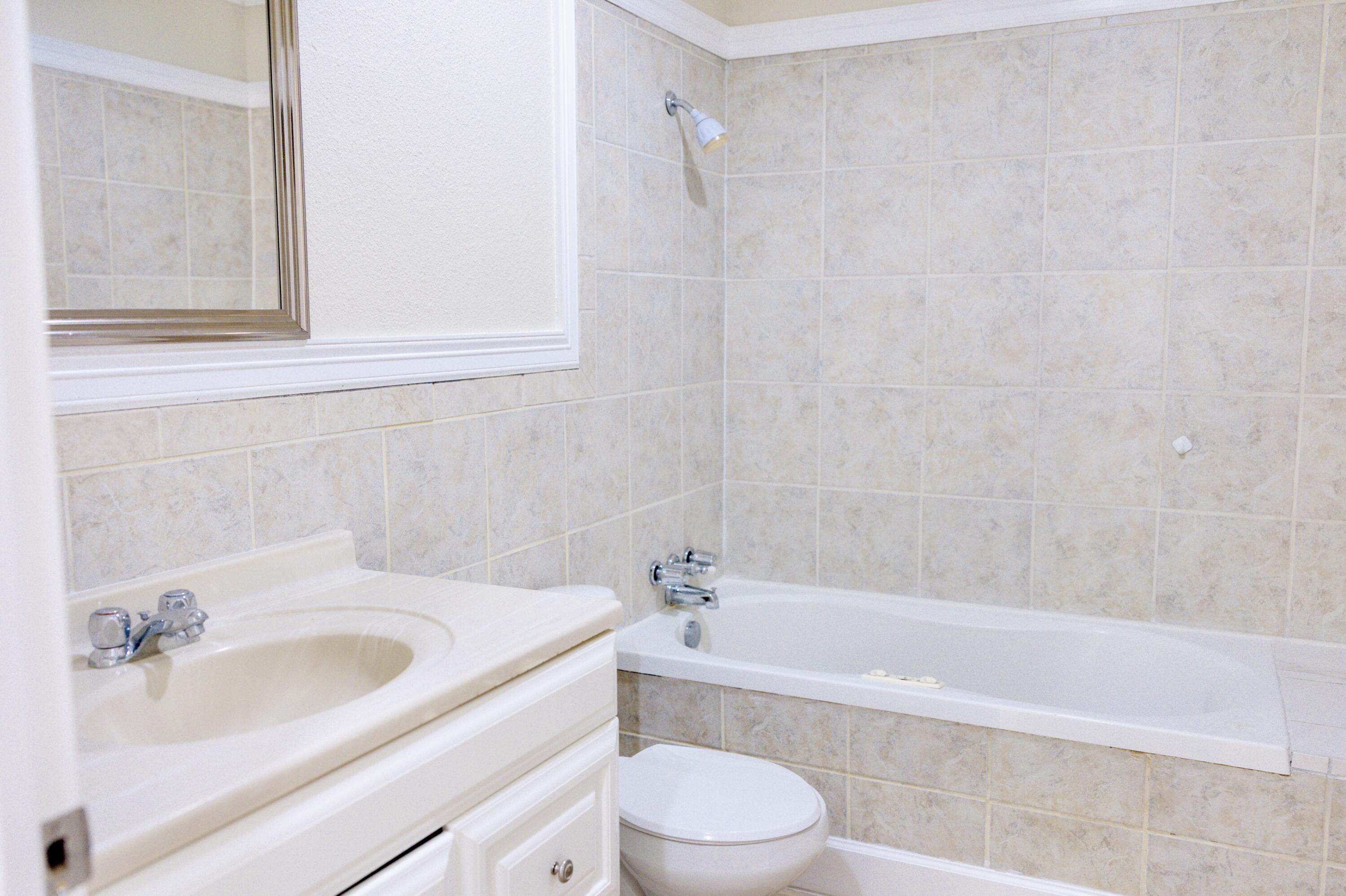 1410 West 8th Street Plainview, TX 79072 - Photo 16 of 24 a bathroom with a sink a toilet and bathtub