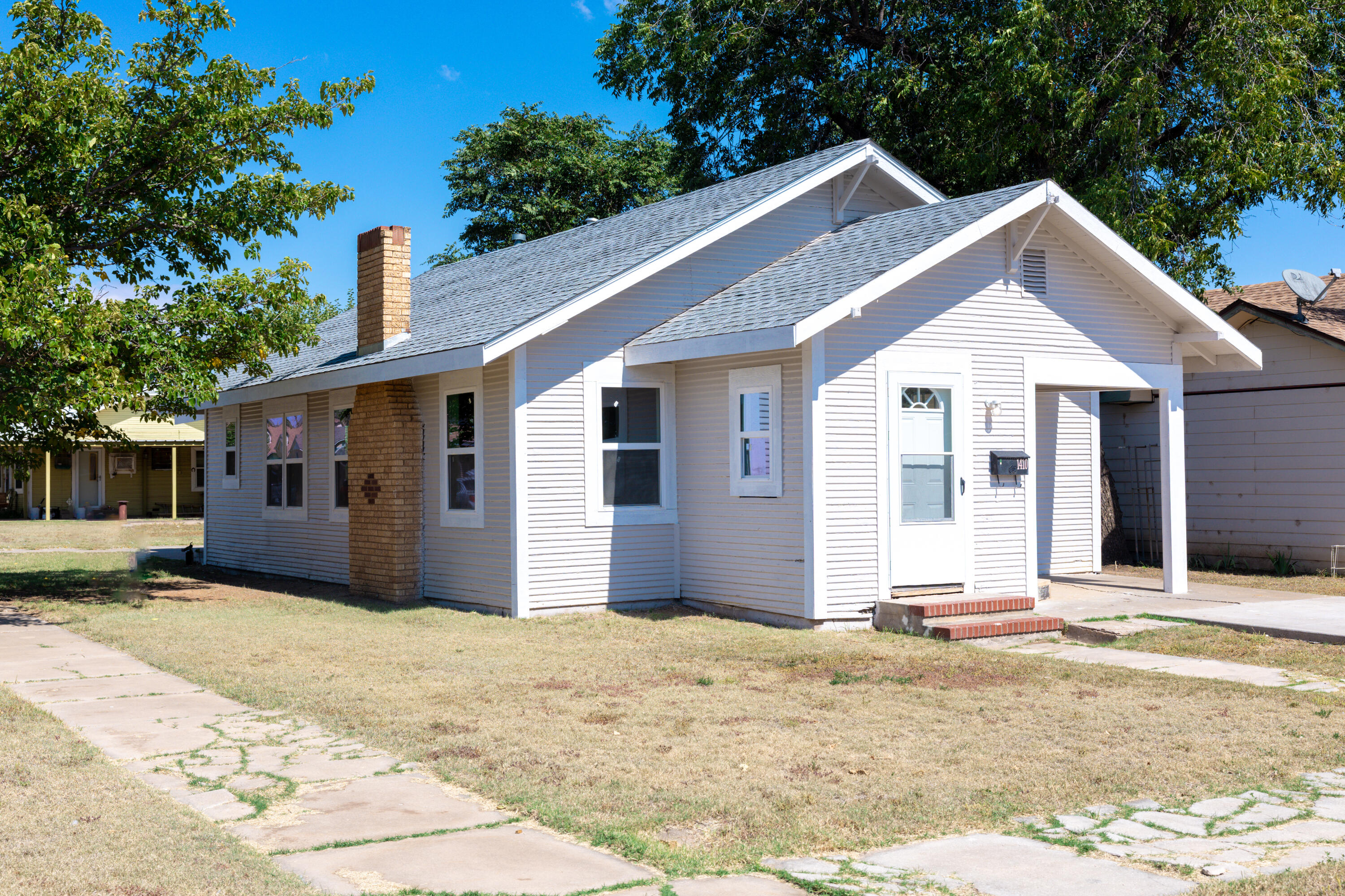 1410 West 8th Street Plainview, TX 79072 - Photo 3 of 24 a front view of a house with a yard and garage