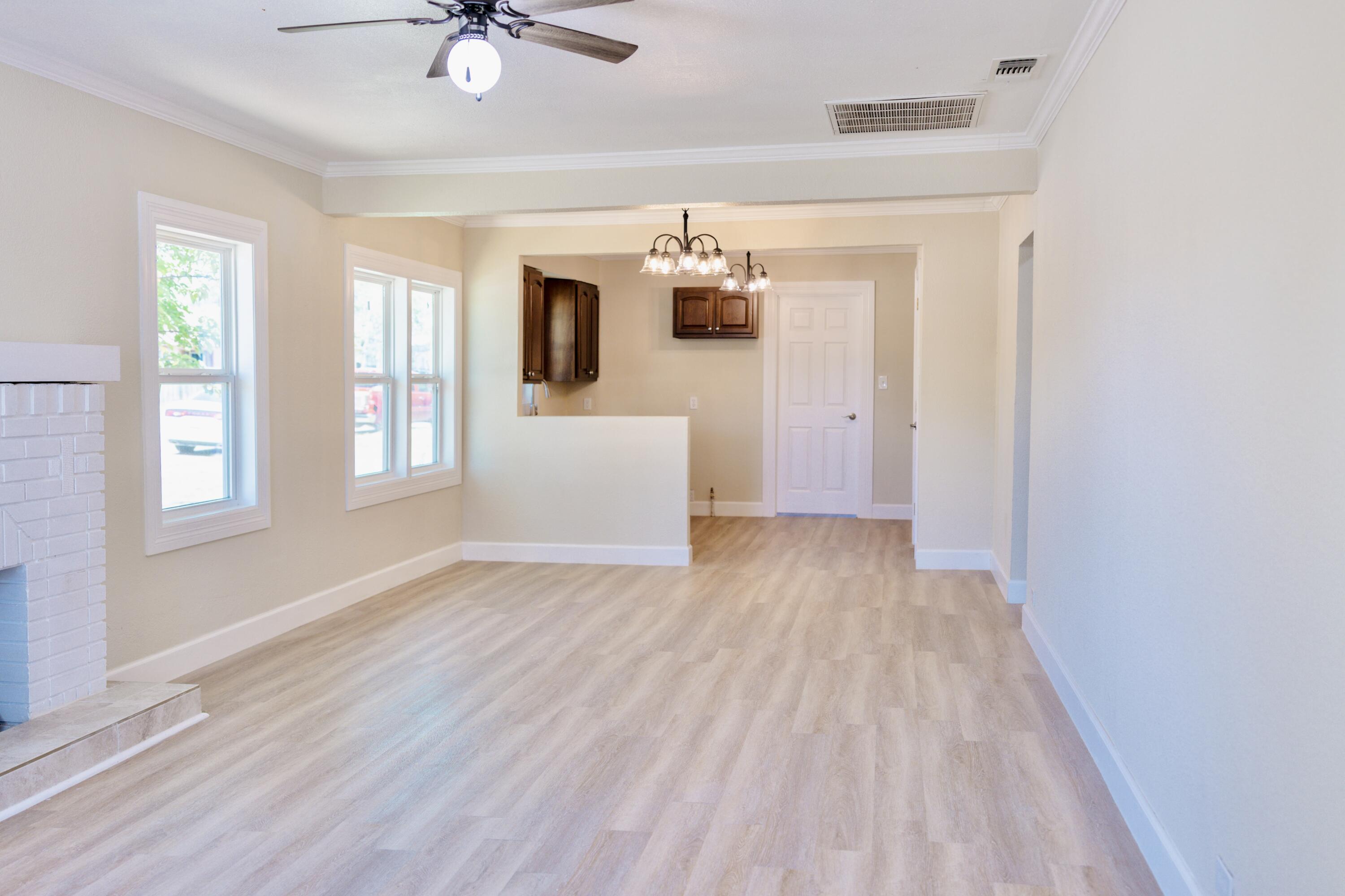 1410 West 8th Street Plainview, TX 79072 - Photo 6 of 24 a view of a livingroom with wooden floor and a ceiling fan