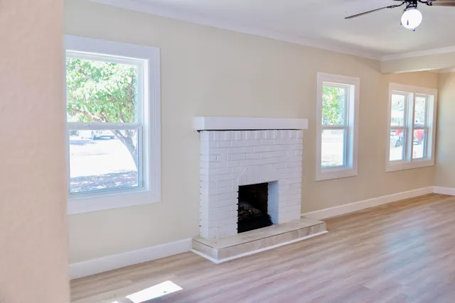 wooden floor fireplace and windows in an empty room