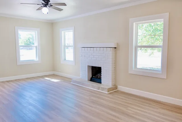 a view of a livingroom with a chandelier a fireplace and wooden floor