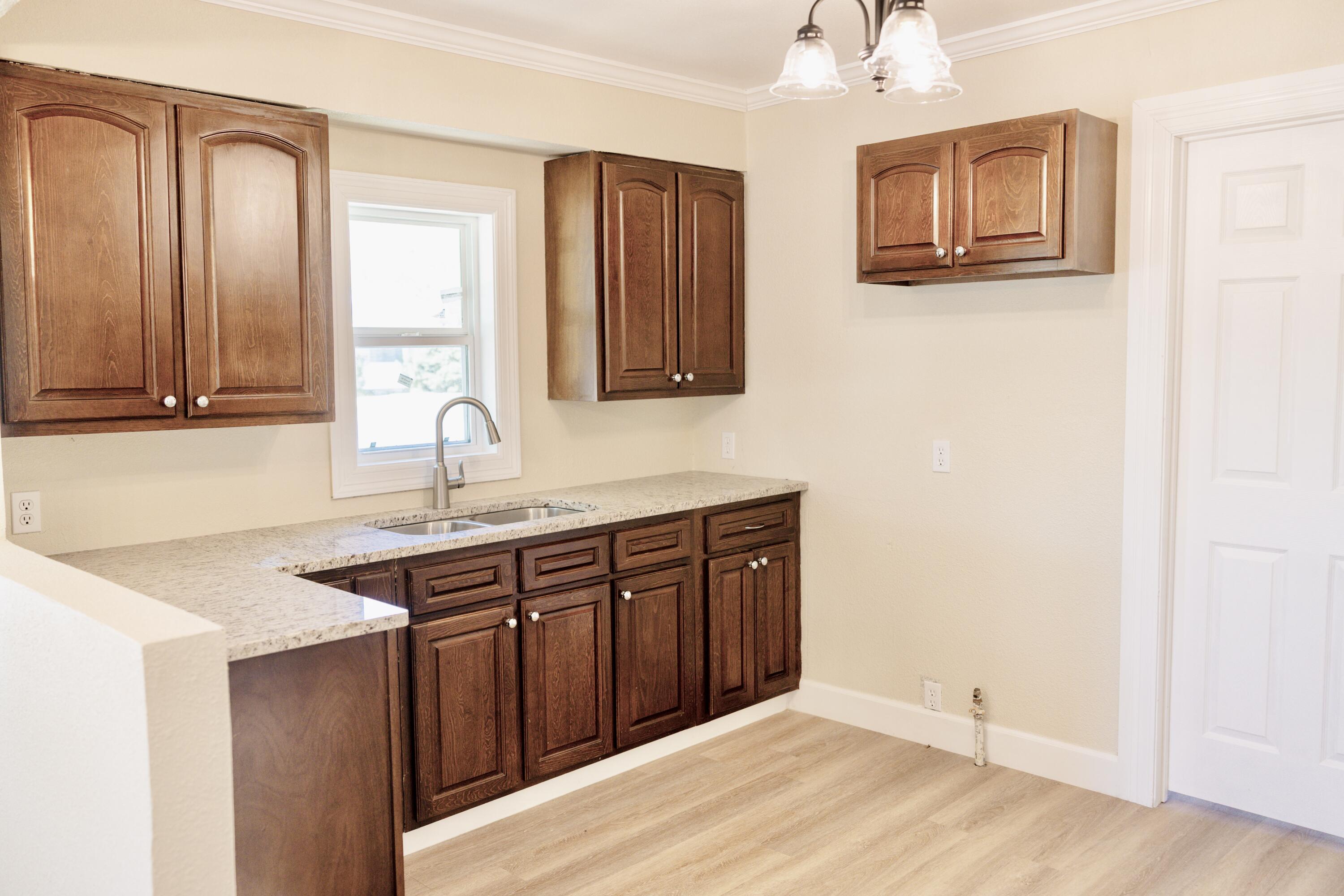 1410 West 8th Street Plainview, TX 79072 - Photo 10 of 24 a kitchen with stainless steel appliances granite countertop a sink and a granite counter tops with wooden floors