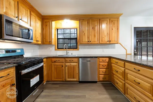 a kitchen with stainless steel appliances granite countertop a stove a sink and a microwave