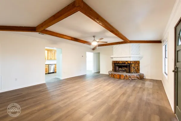 a view of empty room with fireplace and wooden floor