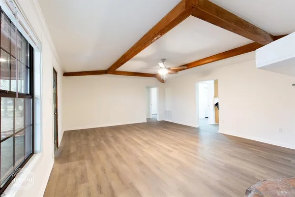a view of empty room with wooden floor