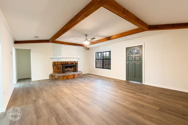 a view of empty room with wooden floor and window