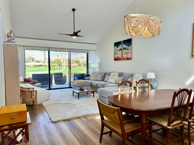 a dining room with furniture a chandelier and wooden floor