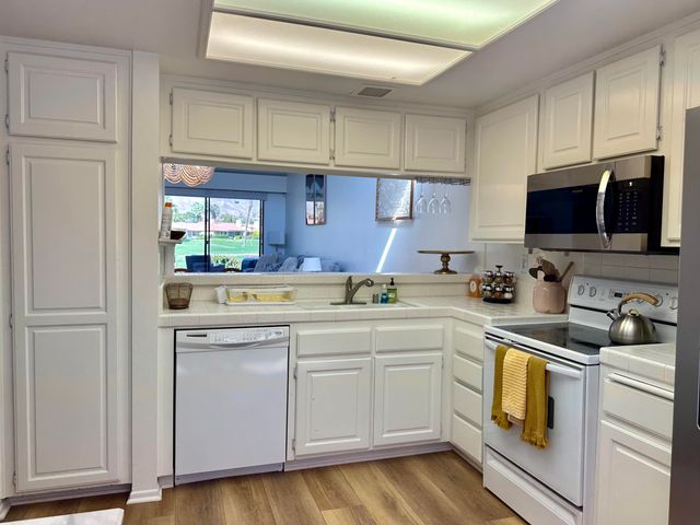 a kitchen with white cabinets and white appliances