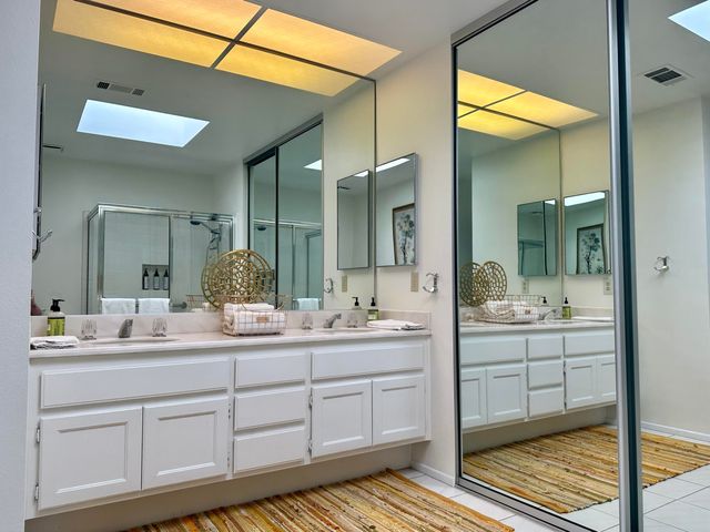 a bathroom with a double vanity sink and mirror