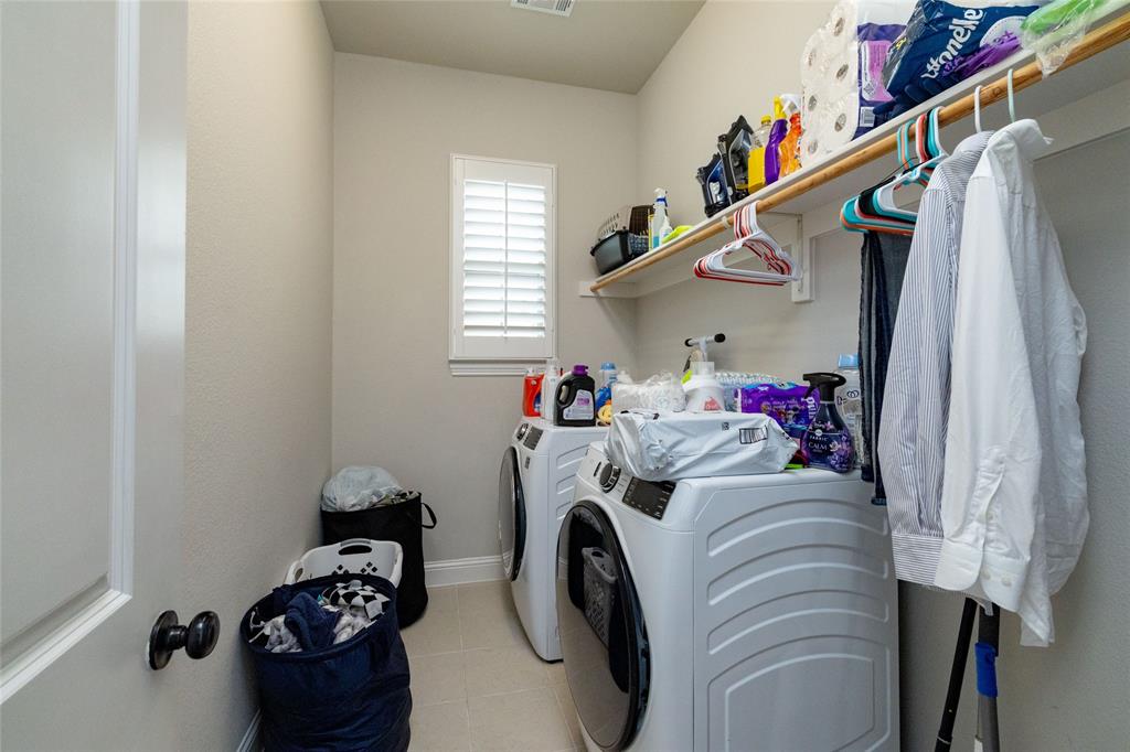 4045 Grove Valley Road Midlothian, TX 76065 - Photo 29 of 34 Laundry room with washer and clothes dryer and light tile patterned floors
