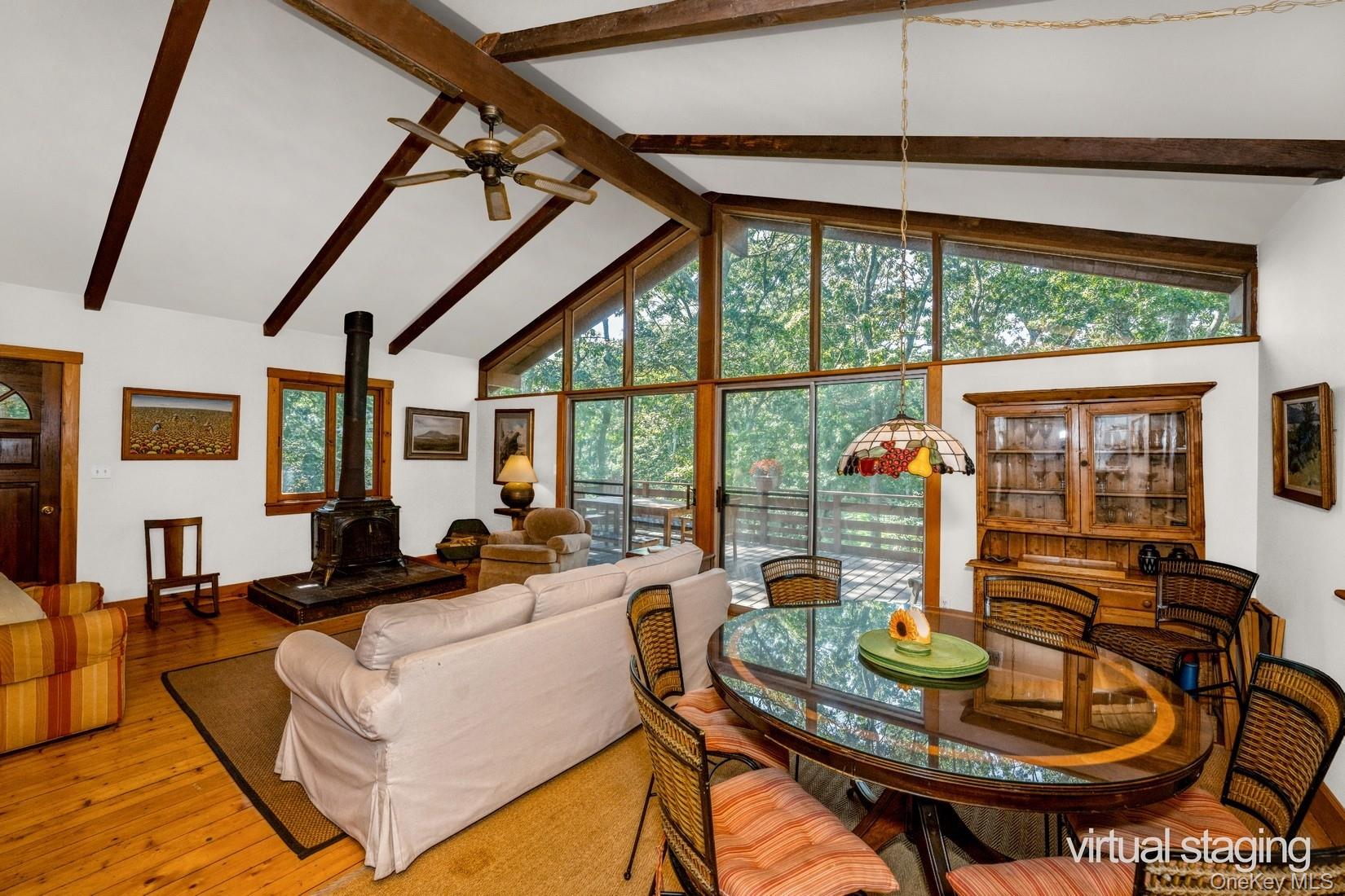 292 Little Fresh Pond Road Southampton, NY 11968 - Photo 13 of 46 Living area featuring beam ceiling, light wood-style flooring, a wood stove, and ceiling fan