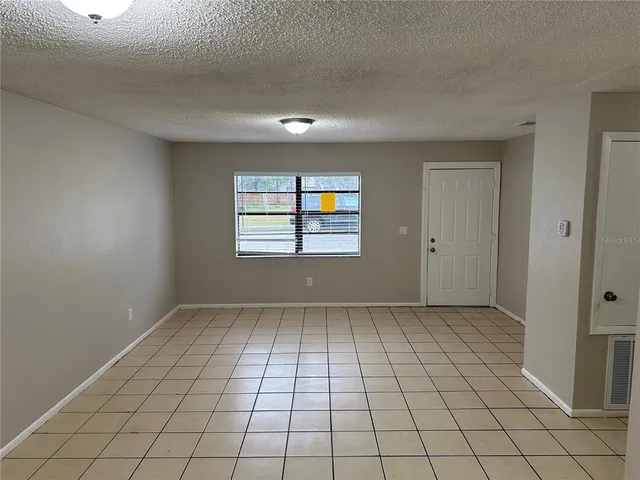 an empty room with white walls and tiles