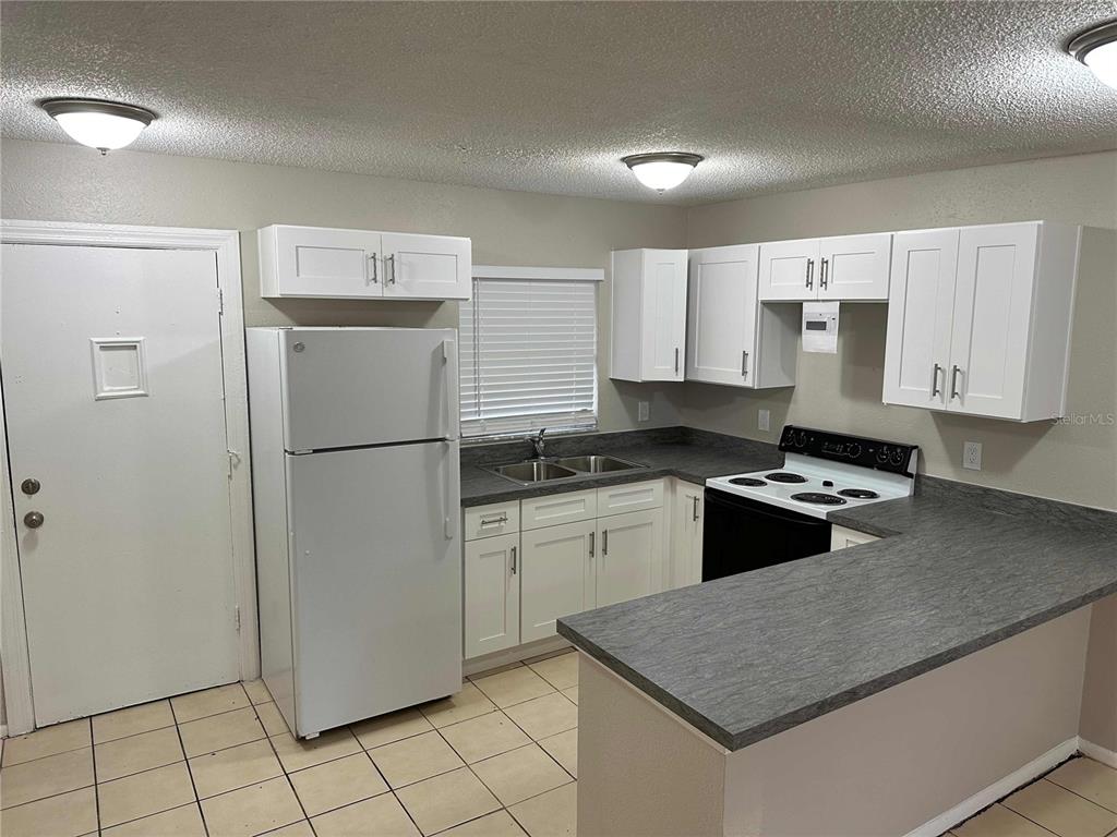 385 Lime Street Maitland, FL 32751 - Photo 7 of 13 a kitchen with granite countertop a refrigerator sink and stove