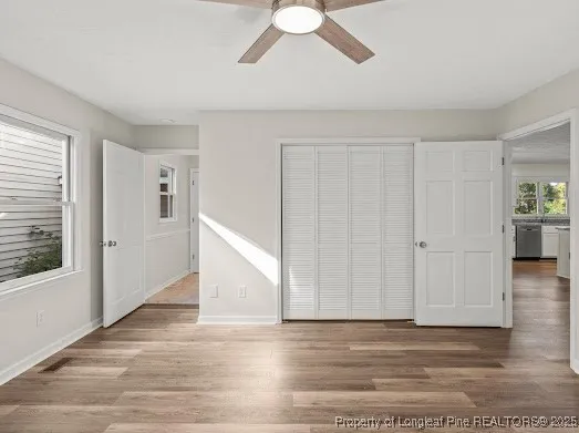 a view of an empty room with window and wooden floor