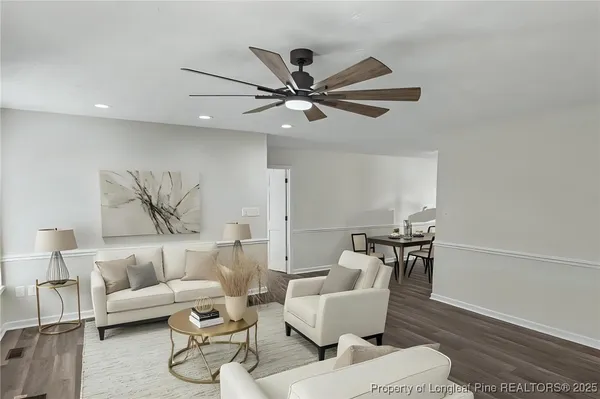 a living room with furniture and a ceiling fan