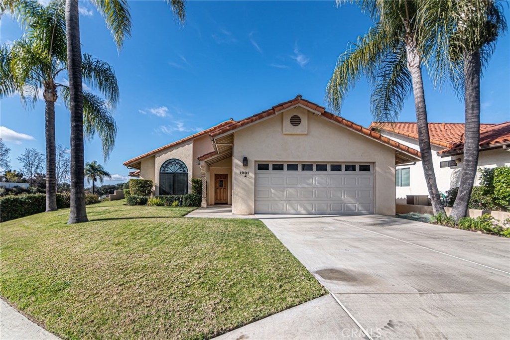 a front view of a house with a garden and trees