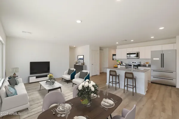 a living room with furniture kitchen view and a flat screen tv