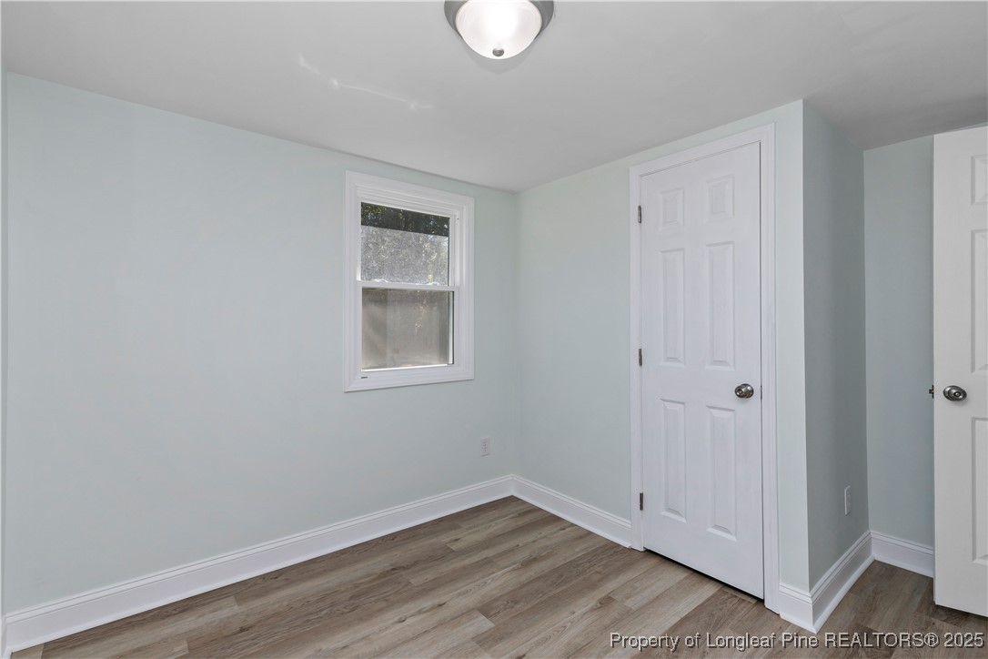 1340 George Perry Lee Road Dunn, NC 28334 - Photo 22 of 31 a view of an empty room with wooden floor and a window