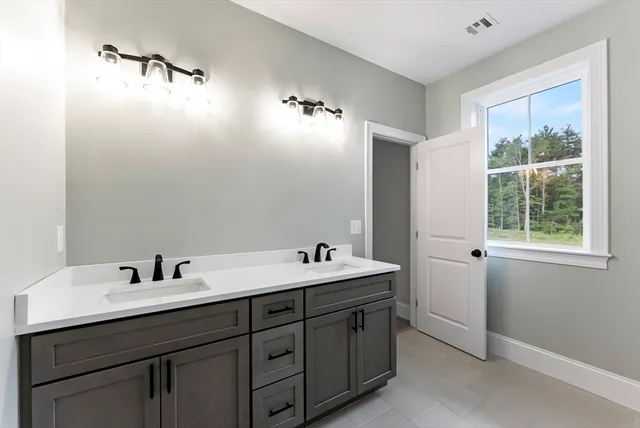 a bathroom with a double vanity sink and a mirror