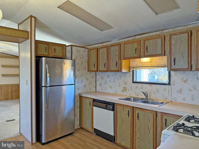 a kitchen with a refrigerator sink and cabinets