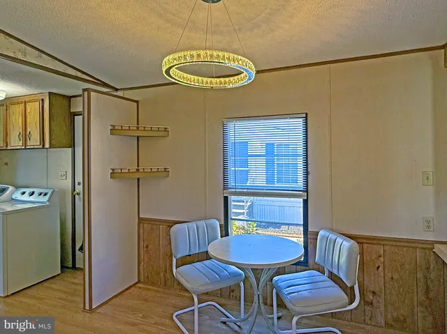 a view of a dining room with furniture a chandelier and wooden floor