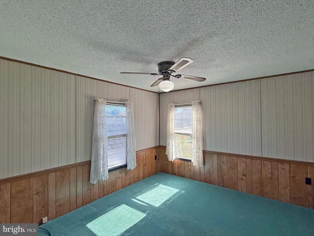 a view of an empty room with a fireplace and a window