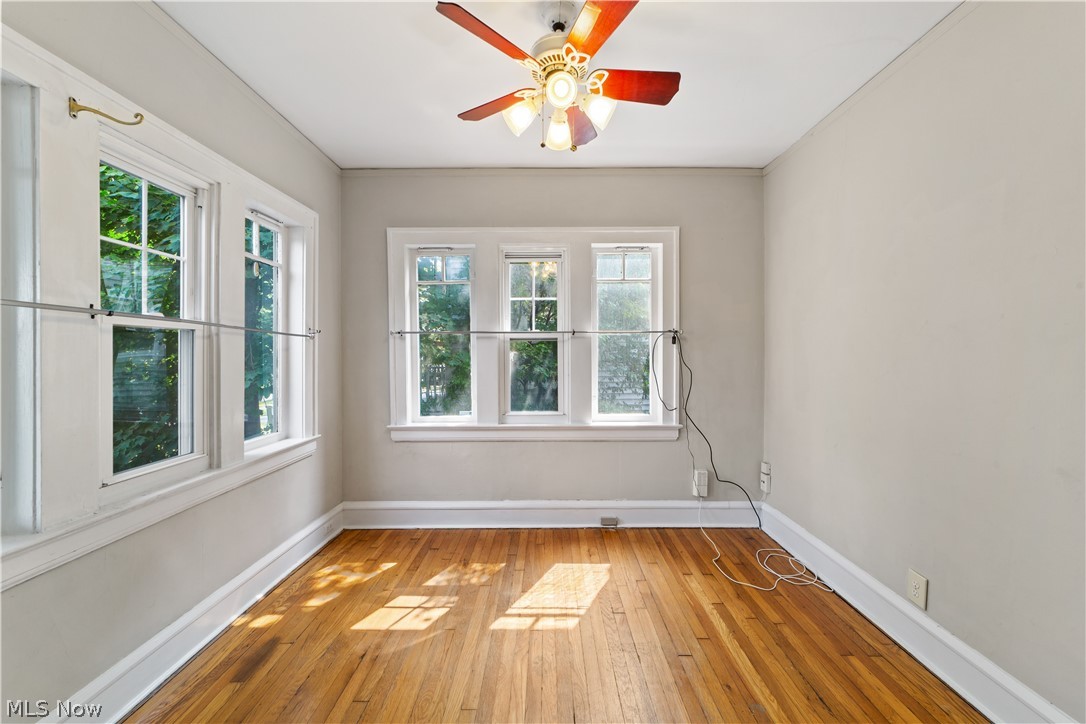 3076 Yorkshire Road Cleveland, OH 44118 - Photo 5 of 47 Empty room with a wealth of natural light, wood-type flooring, and ceiling fan