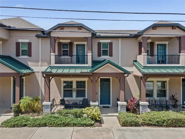 a front view of a house with a yard and potted plants